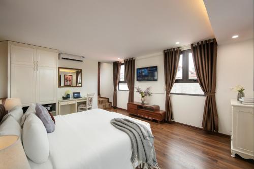 a bedroom with a white bed and two windows at TrangTrang Luxury Hotel in Hanoi
