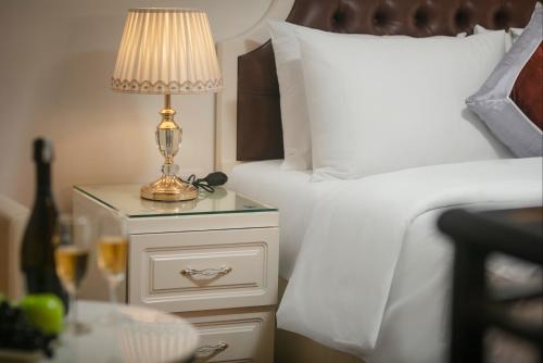 a lamp on a night stand next to two beds at TrangTrang Luxury Hotel in Hanoi