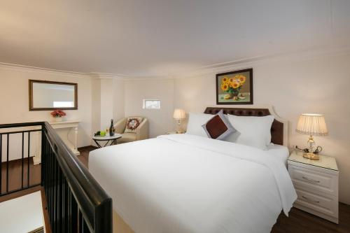 a bedroom with a large white bed and a staircase at TrangTrang Luxury Hotel in Hanoi