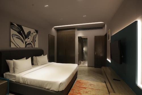 a bedroom with a white bed and a television at Palm Springs Resort in Nashik