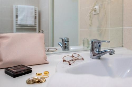 - un lavabo avec un sac rose dans l'établissement Nemea Appart Hotel Home Suite Nancy Centre, à Nancy