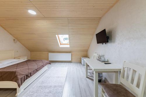 a bedroom with a bed and a desk and a tv at Premium hotel & SPA in Bukovel