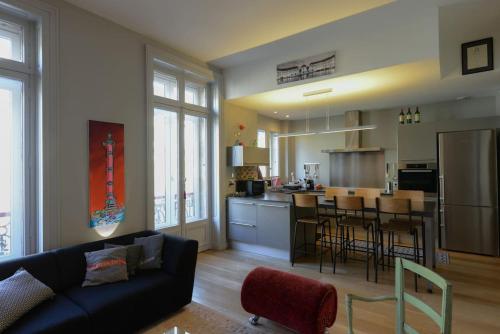 un salon avec un canapé et une cuisine dans l'établissement L'Appartement du Palais, à Bordeaux