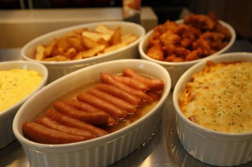 a group of bowls filled with different types of food at Dormy Inn Maebashi in Maebashi