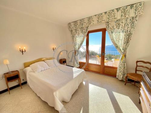une chambre avec un lit et une grande fenêtre dans l'établissement Belle villa piscine vue mer, au Lavandou
