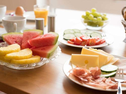 a table with three plates of fruit and cheese at Ferienwohnung Stadtperle Leer 15152 in Leer