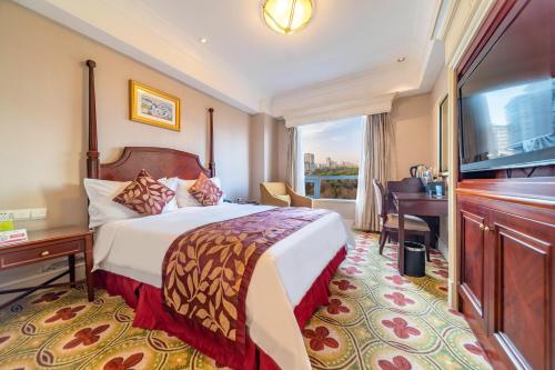 a hotel room with a bed and a television at Ramada Yichang Hotel in Yichang