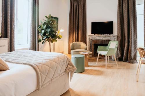een slaapkamer met een bed, een open haard en een tv bij Domitys Les Raisins Bleus in Villiers-sur-Marne