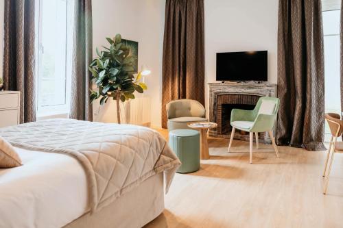 a bedroom with a bed and a fireplace and a tv at Domitys Les Raisins Bleus in Villiers-sur-Marne