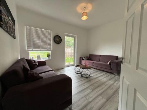 una sala de estar con 2 sofás y una ventana en Charming 2BR Cottage - Fully Furnished - 10min LGW - Free Parking, en Crawley