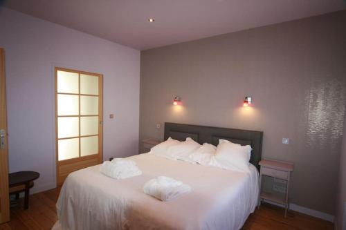 une chambre avec un lit blanc avec deux serviettes dessus dans l'établissement Villa coup de cœur, 50 m plage et Thermes marins, à Saint-Malo