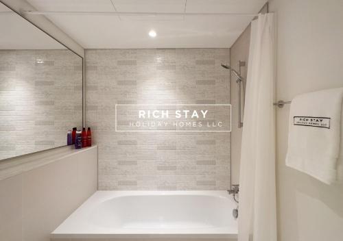 a bathroom with a tub and a sign on the wall at Sunrise Bay 3BR EMAAR Beachfront Dubai Harbour by Rich Stay in Dubai