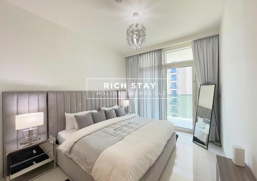 a bedroom with a large bed and a chandelier at Sunrise Bay 3BR EMAAR Beachfront Dubai Harbour by Rich Stay in Dubai