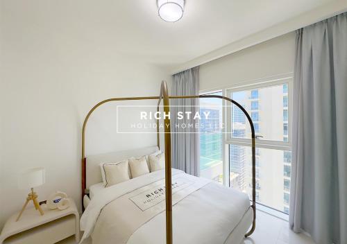 a bedroom with a bed and a large window at Sunrise Bay 3BR EMAAR Beachfront Dubai Harbour by Rich Stay in Dubai