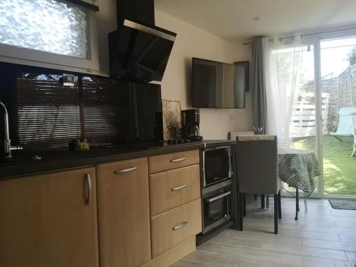 une cuisine avec un évier et une cuisinière four supérieur dans l'établissement Studio indépendant dans villa avec piscine Cagnes, à Cagnes-sur-Mer