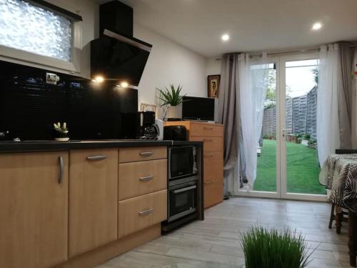 Il comprend une cuisine équipée d'une cuisinière. four supérieur à côté d'une fenêtre dans l'établissement Studio indépendant dans villa avec piscine Cagnes, à Cagnes-sur-Mer