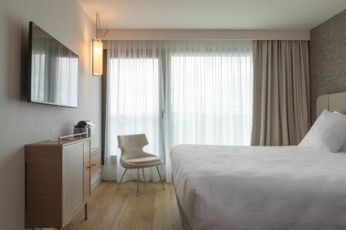 a hotel room with a bed and a chair at Oceania Saint Malo in Saint Malo