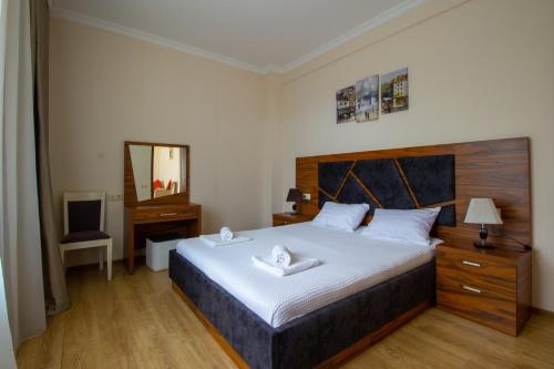 sypialnia z dużym łóżkiem i lustrem w obiekcie Golden Fleece Hotel w mieście Ureki