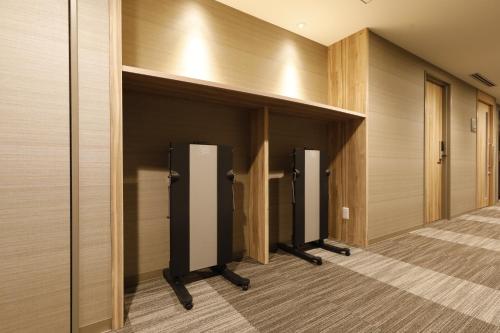 a row of elevators in a hallway with wooden walls at Dormy Inn Maebashi in Maebashi