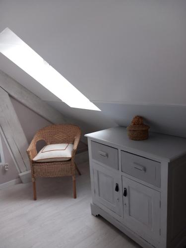シャテルローにあるLes chambres de Béaのドレッサーと椅子が備わる天井の客室です。