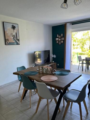 une salle à manger avec une table et des chaises en bois dans l'établissement Les villas de Melody, à Santa-Maria-Poggio