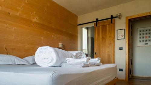 a bedroom with a bed with white sheets and towels at Le Spine B&B sulla Via Francigena in Berceto
