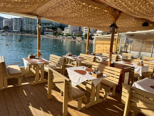 een restaurant met tafels en stoelen en uitzicht op het water bij Hotel Kuč in Budva