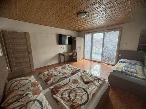 a bedroom with two beds and a desk in it at Chalupa Dešná in Dešná