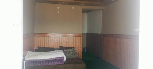 a small bedroom with a bed in the corner at nako valley home stay in Nako