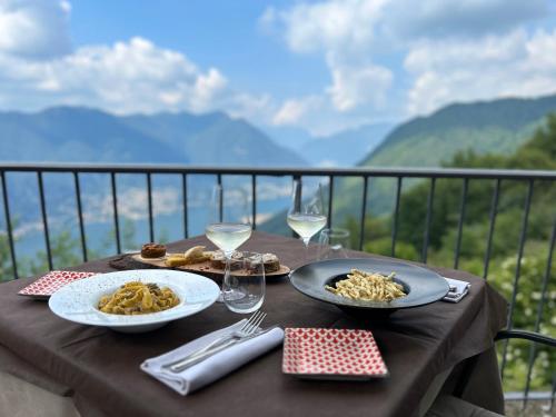 una mesa con dos platos de comida y copas de vino en Hotel Paradiso Como, en Brunate