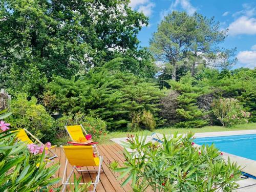 une terrasse avec deux chaises et une piscine dans l'établissement 1km plage du Mauret- maison pour 6 avec piscine, à Andernos-les-Bains