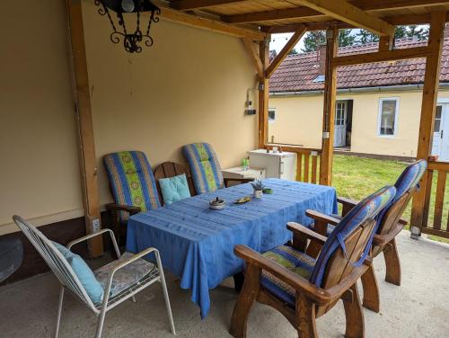 a table with chairs and a blue tablecloth on a patio at Ferienhaus Zalaszentgrot in Zalaszentgrót