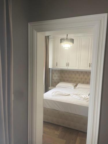 a bedroom with a bed with a chandelier above it at Himara luxury apartments in Himare
