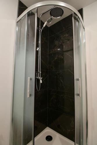 une douche dans une salle de bain avec une porte vitrée dans l'établissement Le Rétro de la Gare - FloBNB, à Laon