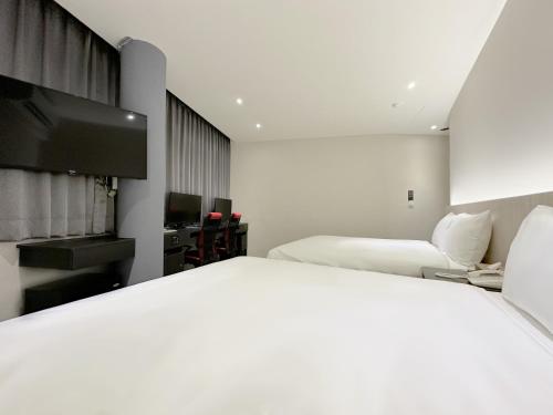 a bedroom with two beds and a flat screen tv at 福棧 Full.Inn in Dajia