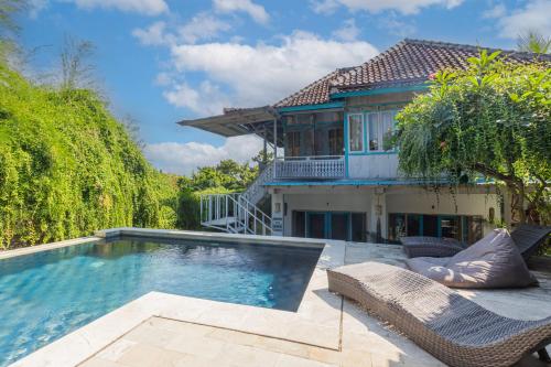 a house with a swimming pool in front of a house at Golden Hill Cottage Nusa Penida in Nusa Penida