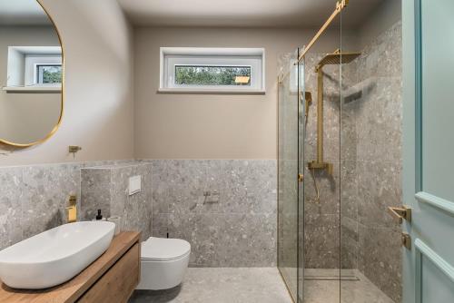a bathroom with a sink toilet and a glass shower at NEW Stylish villa Tenera with private pool, 3 bedrooms in Tugare