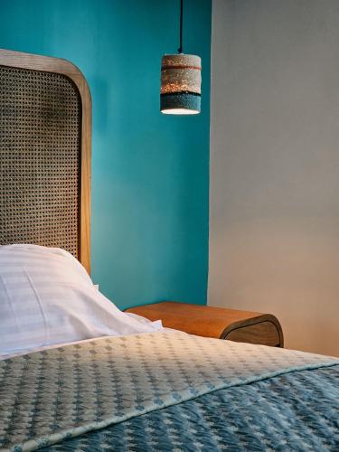 a bedroom with a bed and a blue wall at Beit Mema in Aḑ Ḑahr