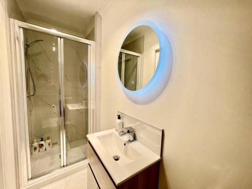 a white bathroom with a sink and a mirror at Nice 3 bedroom Townhouse U2 in Hamilton