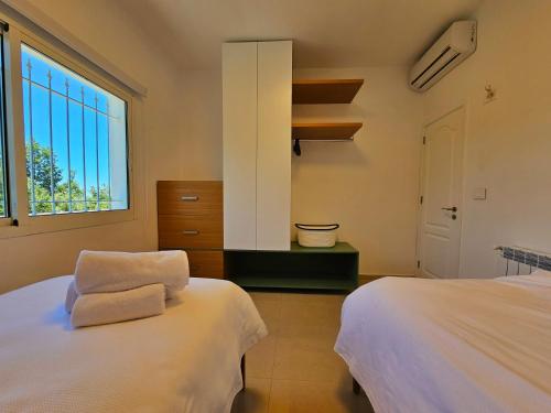 - une chambre avec 2 lits et une fenêtre dans l'établissement Beit Mema, à Aḑ Ḑahr