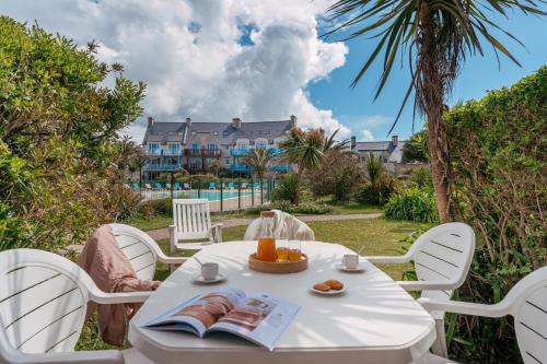 une table avec une assiette de nourriture et une maison dans l'établissement Résidence Pierre & Vacances Cap Marine, au Guilvinec