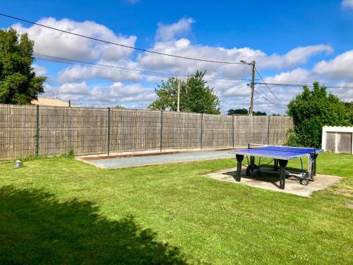 - une table de ping-pong dans une cour avec une clôture dans l'établissement LES ROCHES gîte, à Corme-Royal