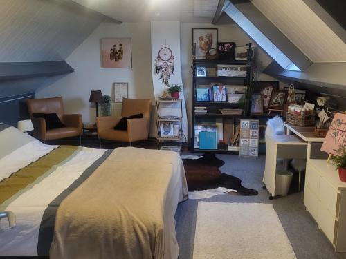 Schlafzimmer mit einem Bett, einem Schreibtisch und Stühlen in der Unterkunft Anja's House in Breda