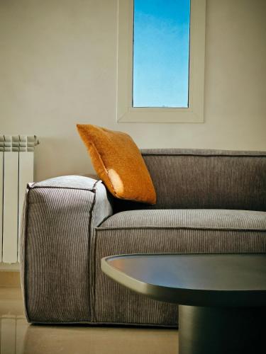 a couch with a pillow on it with a table at Beit Mema in Aḑ Ḑahr