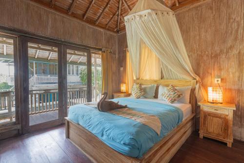 a bedroom with a bed with a dolphin on it at Golden Hill Cottage Nusa Penida in Nusa Penida