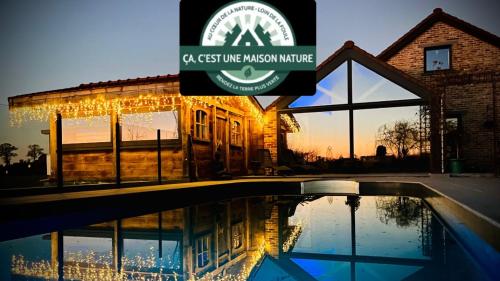 a building with a sign next to a swimming pool at Les Sources d'Hon - Gîte & Espace wellness in Hon-Hergies