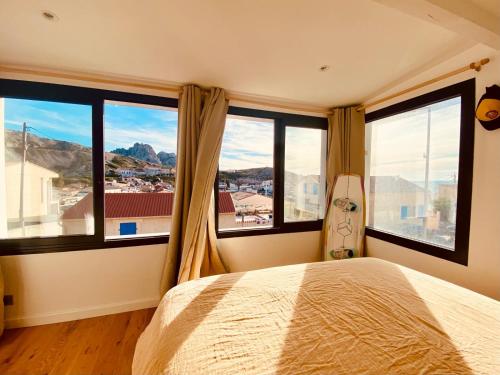 - une chambre avec un lit et de grandes fenêtres avec vue dans l'établissement Maison bord de mer avec jacuzzi, à Marseille