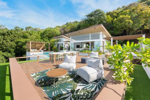 un patio al aire libre con muebles blancos y una piscina en Infinity Seaview Villa, en Mae Nam
