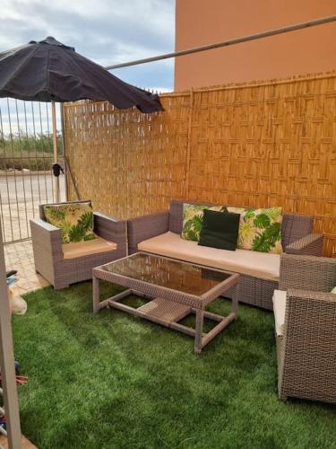 a patio with two couches and a table and an umbrella at appartement bien située in Saidia 