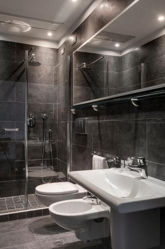 a bathroom with two sinks and a shower and a toilet at Hotel Verona in Verona